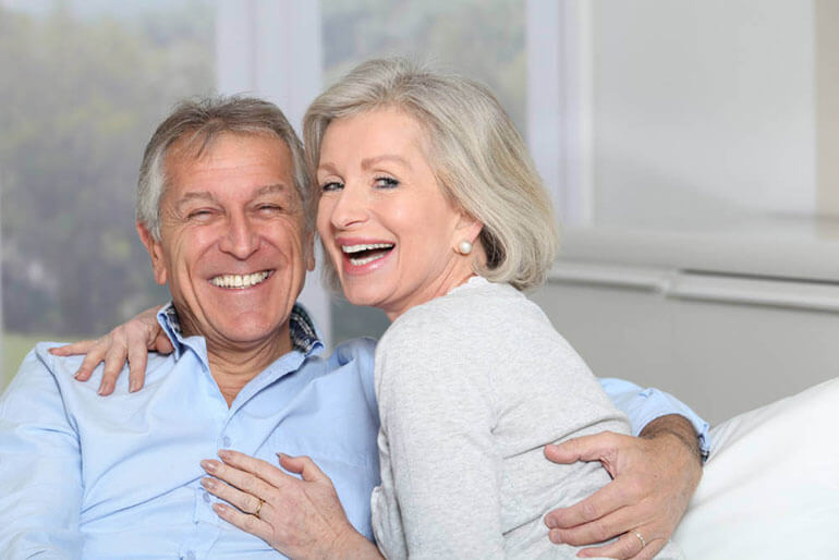 Happy elderly couple with perfect smiles.
