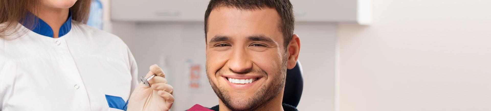 A happy man with a perfect smile during a dental appointment..