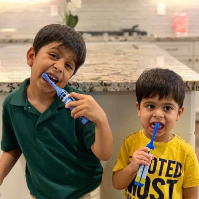Two little boys brushing their teeth.